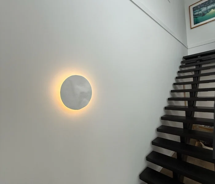 Staircase wall with glowing halo light and modern design.