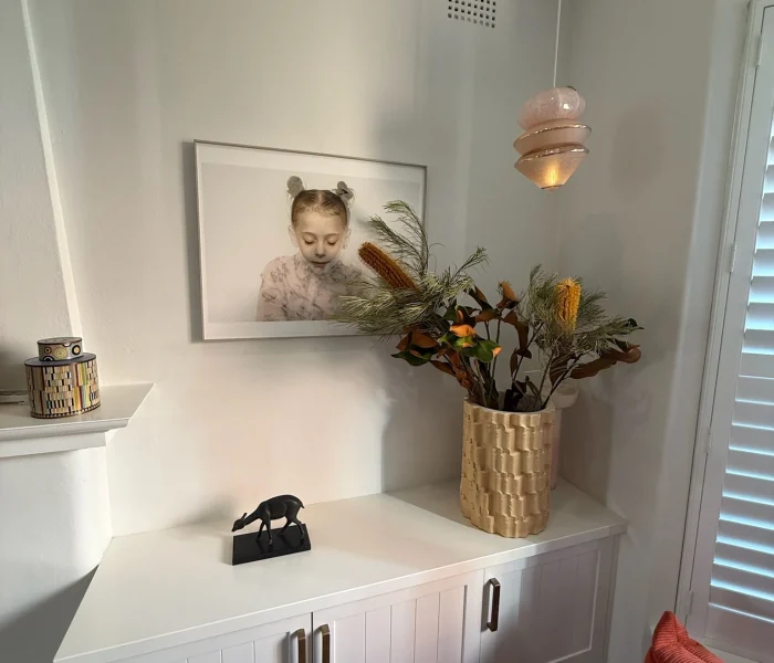 Styled console table with framed artwork and floral arrangement.