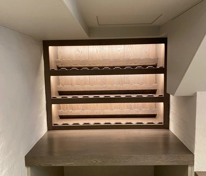 Wine cellar with timber shelves and atmospheric lighting.