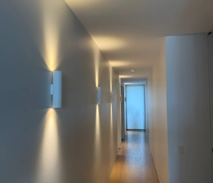 Minimal hallway with recessed lighting and soft wall wash.