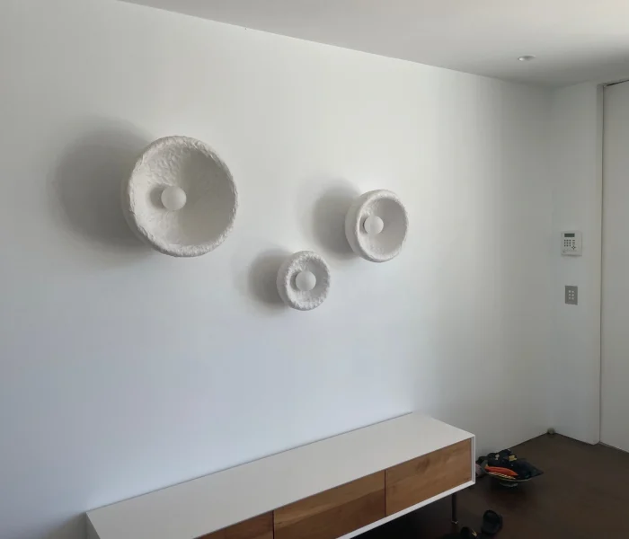 Decorative wall sconces arranged as sculptural lighting pieces.